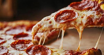 Porción de pizza con pepperoni y mozzarella derretida